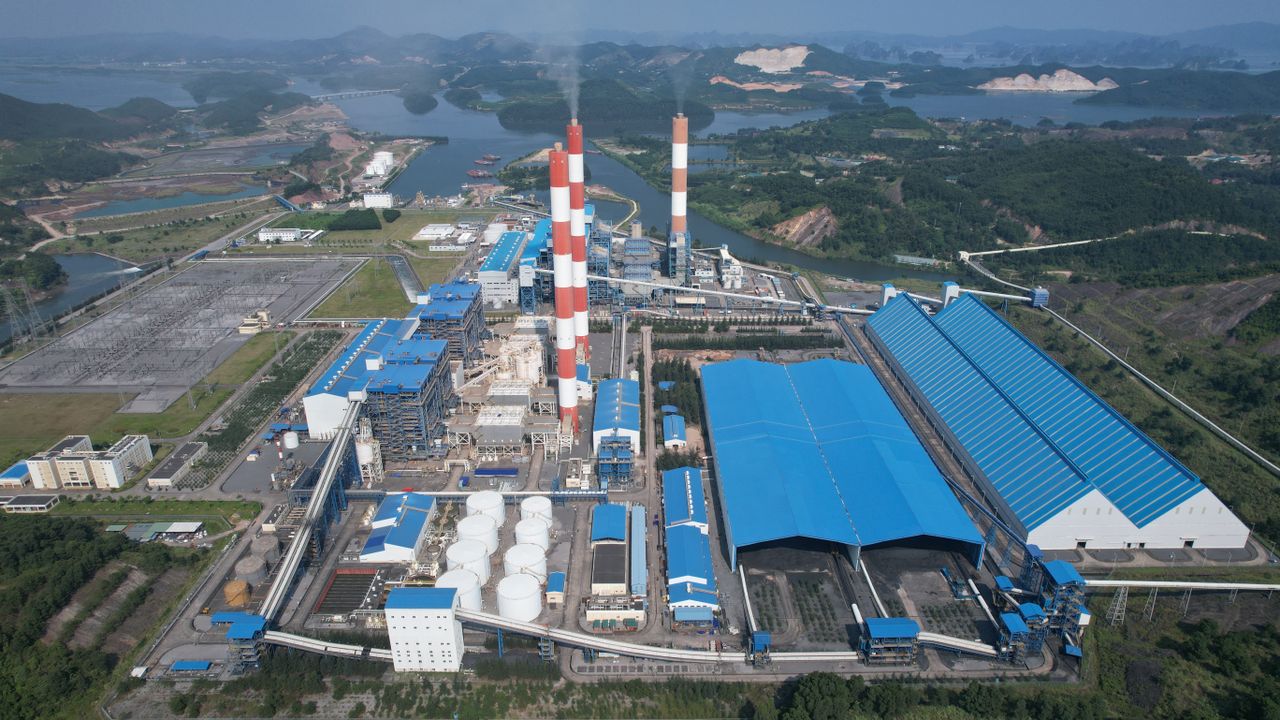 gallery-02 Aerial view of a major industrial plant in Cẩm Phả, Quảng Ninh, Vietnam, with chimneys and blue-roofed structures.